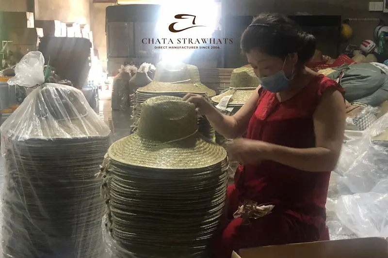 Final quality inspection of straw hats before packaging at Chata Strawhats factory