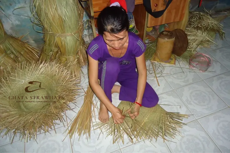 Vietnamese woman weaving handmade straw hats