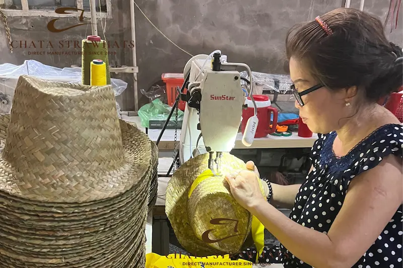 Woman sewing wholesale straw hats at a Vietnam factory